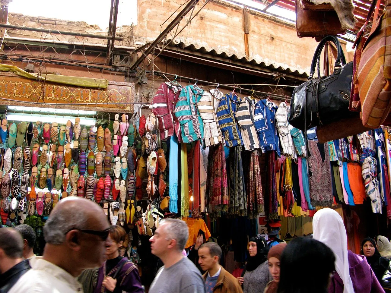 Maroko | Kolorowe tkaniny i ubrania na suku w Marrakeszu