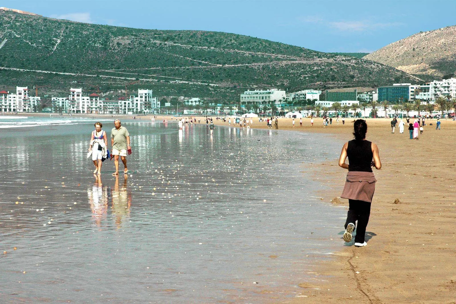 Plażowicze na szerokiej, piaszczystej plaży w Agadirze w słoneczny dzień